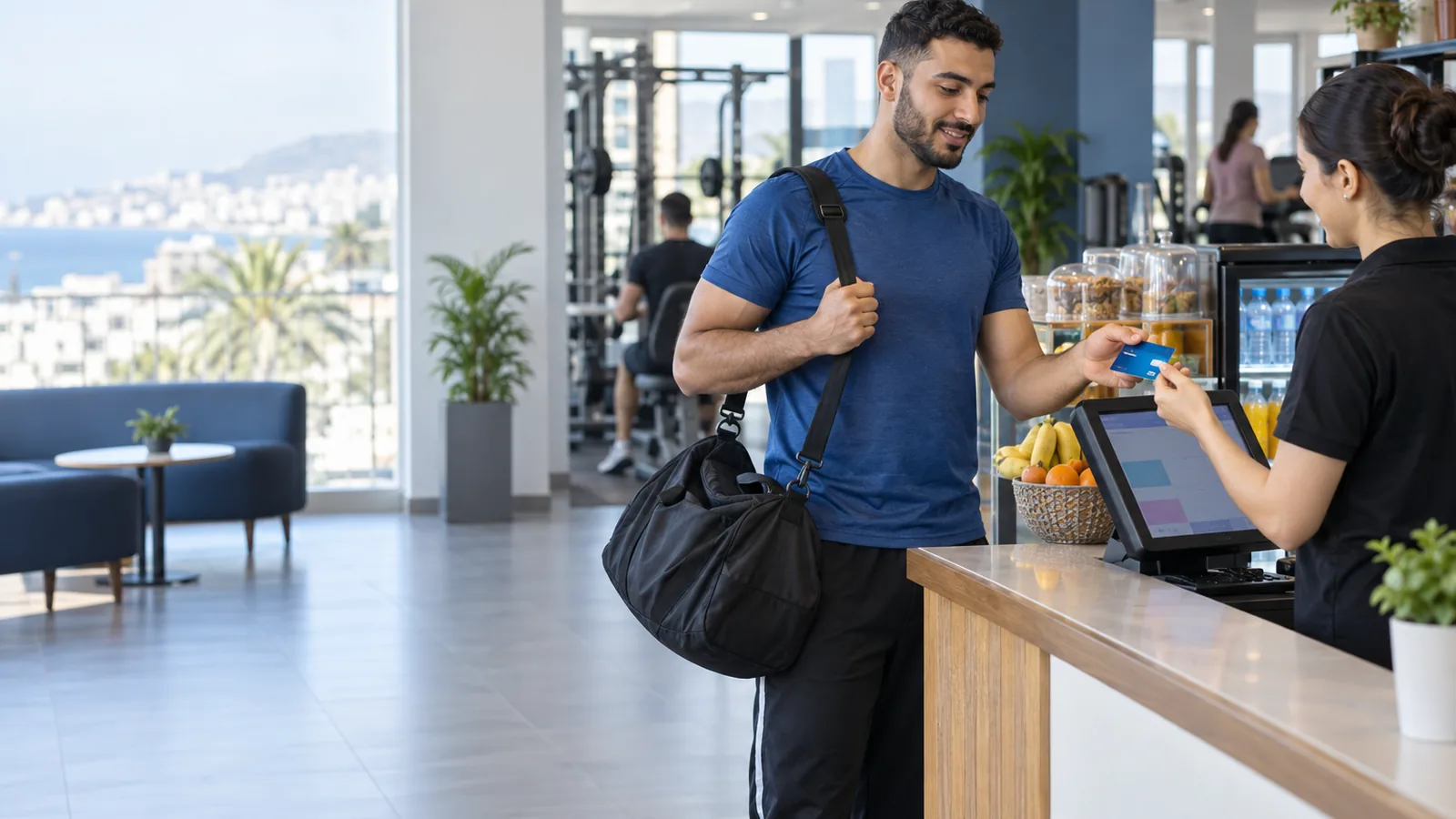 Member of a sports club in Algeria showing a membership card to the snack-bar cashier at a touchscreen till